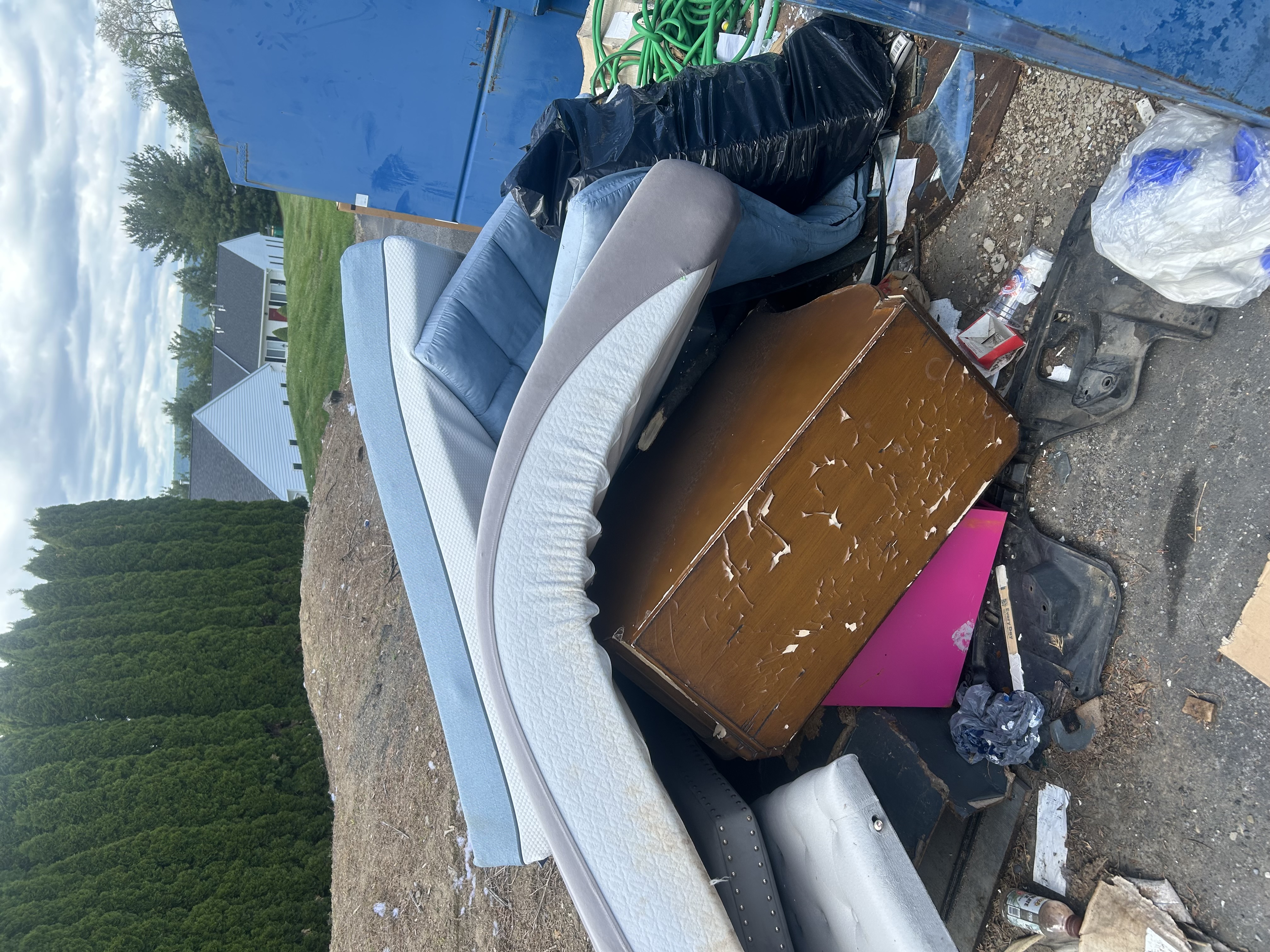Outdoor pile of furniture and mattresses ready for haul-away