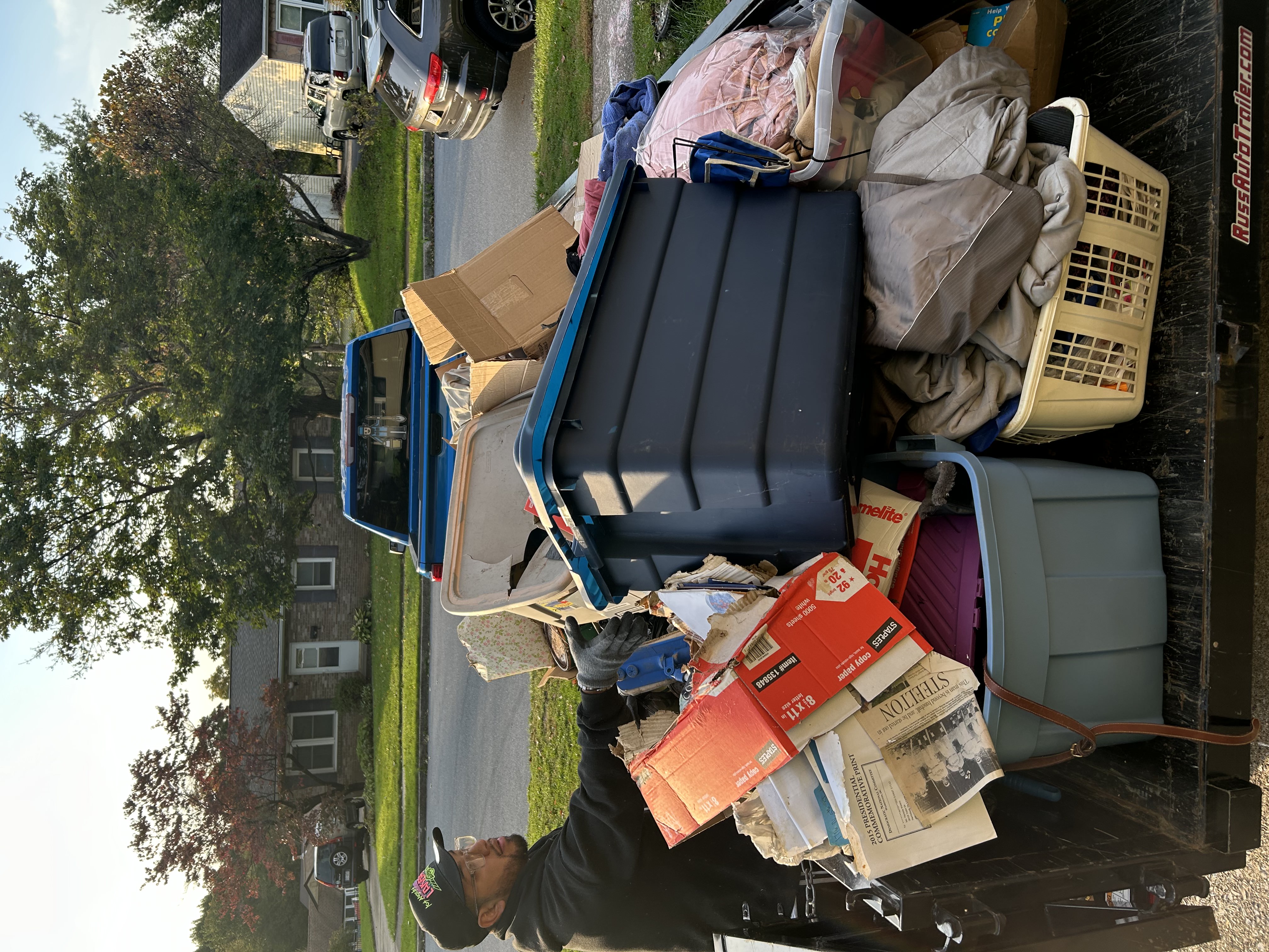 Junk Squad worker loading a trailer with household items during a local cleanout